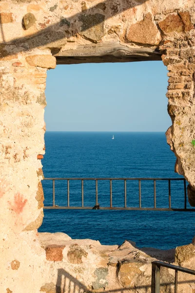 Cadeados em torre de saraceno sobre o mar com barco à vela — Fotografia de Stock