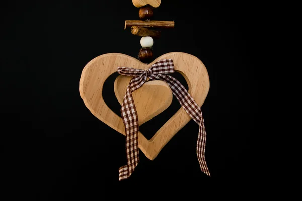 लकड़ी की गेंदों के साथ रस्सी पर लकड़ी का दिल, बीच में एक धनुष, के — स्टॉक फ़ोटो, इमेज
