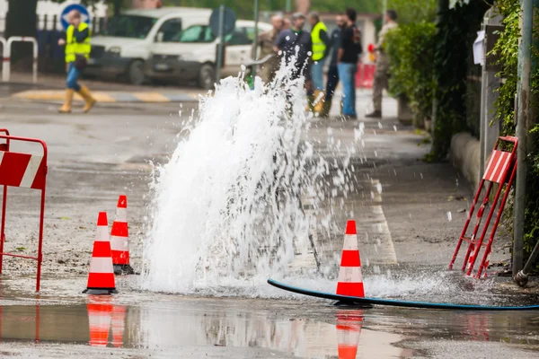 Straße schüttet Wasser neben Verkehrskegel — Stockfoto