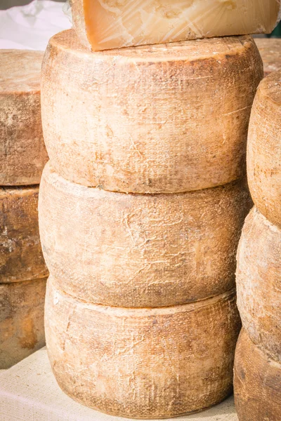 Gestapelde afgeronde kaas te koop in de markt — Stockfoto