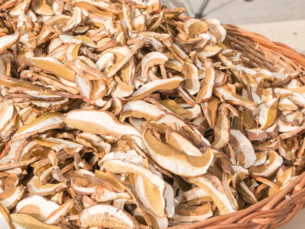 Dried porcini mushrooms in wicker bowl — Stock Photo, Image