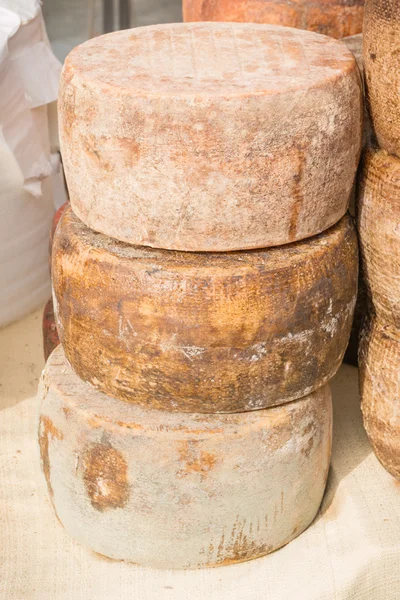 Stacked rounded cheese for sale in market — Stock Photo, Image