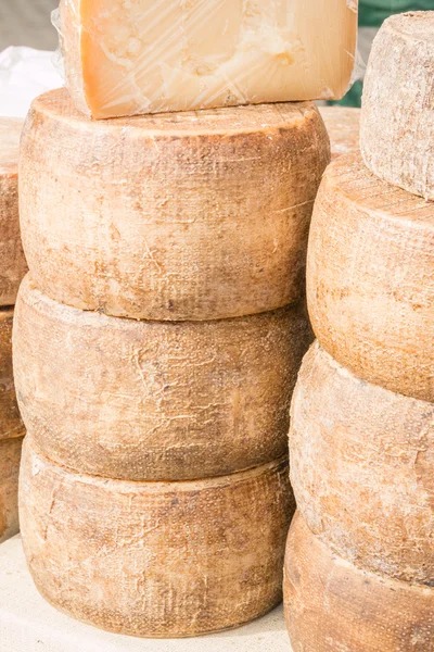 Gestapelde afgeronde kaas te koop in de markt — Stockfoto
