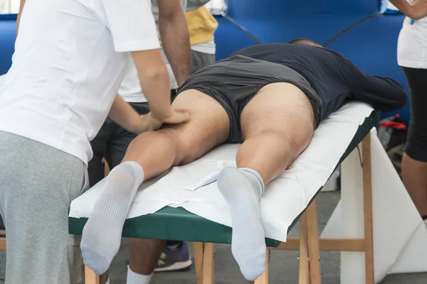 Atletas relaxamento massagem antes do evento desportivo — Fotografia de Stock