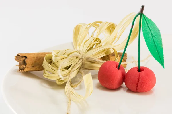 Sweet marzipan cherry fruit with cinnamon spicy stick decoration — Stock Photo, Image