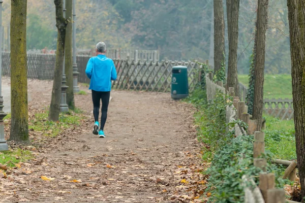 Uomo anziano che fa jogging nel parco in autunno — Foto Stock