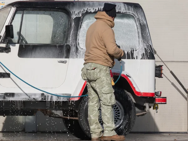 Man washing his car with a jet of water — Stock Photo, Image