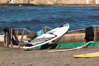 siyah ve beyaz sörf tahtası wetsuits yakınındaki ip üzerinde