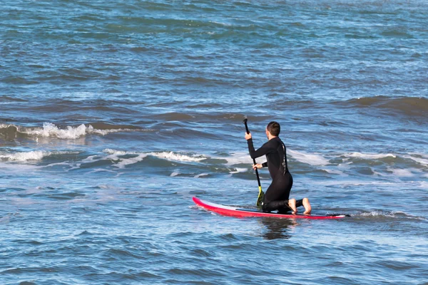 Homem paddleboarding na placa vermelha, surfista — Fotografia de Stock