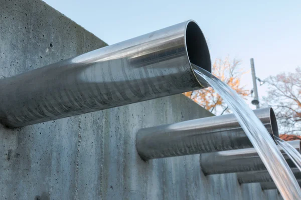 Water flowing out from steel pipes — Stock Photo, Image