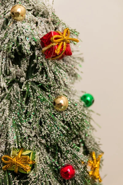 Green and white little xmas tree with balls and gifts — Stock Photo, Image