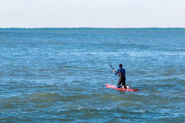 Homem paddleboarding na placa vermelha, surfista — Fotografia de Stock