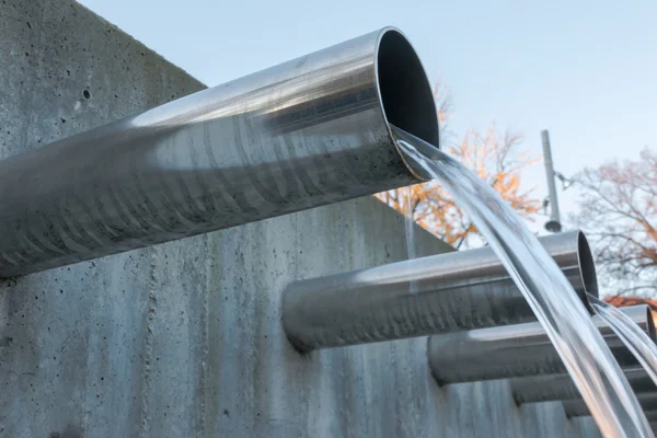 Water flowing out from steel pipes — Stock Photo, Image