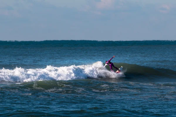 Surfer violett Neoprenanzug auf der Welle — Stockfoto