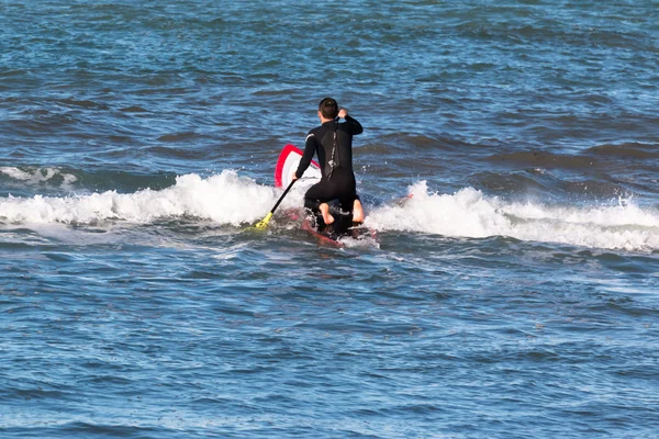 Man paddleboarding op rode bord, surfer — Stockfoto