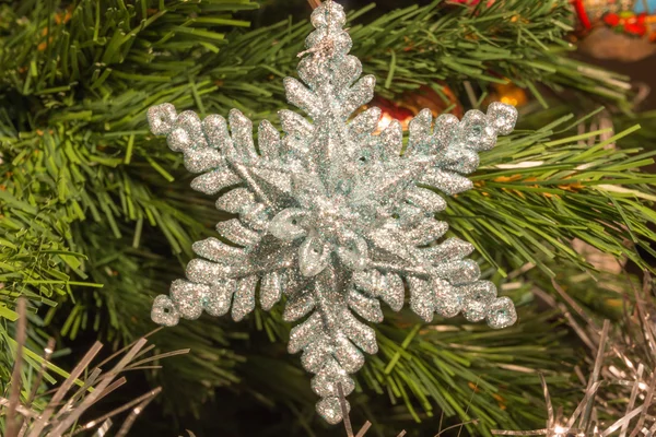 Bright silver six point star decoration on christmas tree — Stock Photo, Image