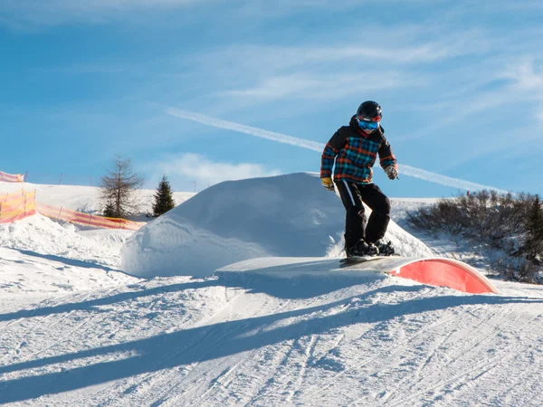 Snowboarder estilo livre com capacete no parque de neve — Fotografia de Stock