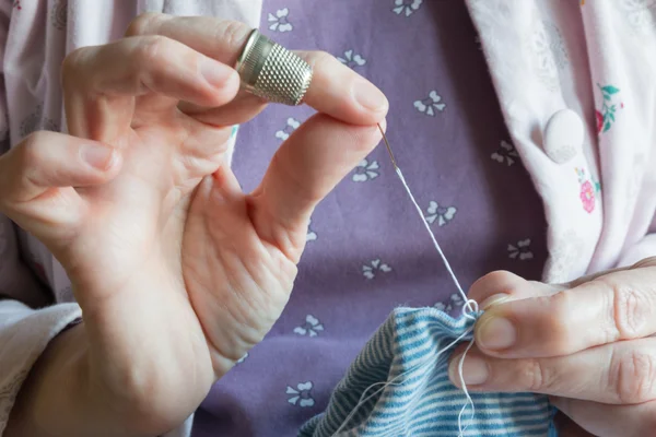 Orlo di un vestito, mani di donna cucito — Foto Stock