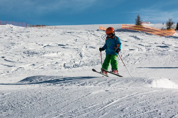 Piccolo sciatore si esibisce salto nella neve — Foto Stock