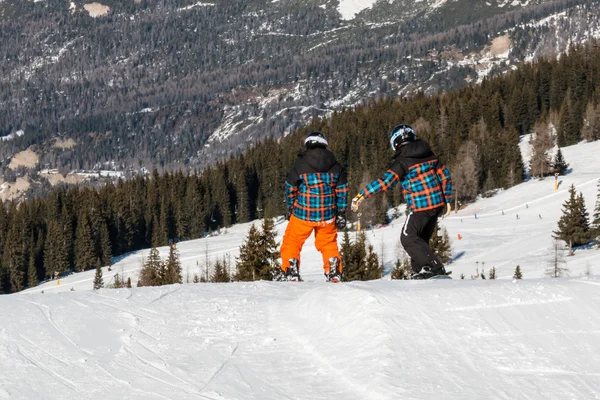 Snowboarders freestyle avec casque dans snowpark, jumeaux — Photo