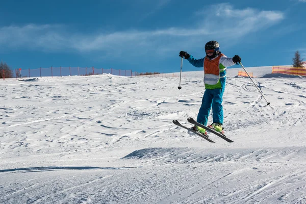 Pouco esquiador executa salto na neve — Fotografia de Stock