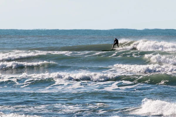 Surfer negru wetsuit echitatie val — Fotografie de stoc gratuită