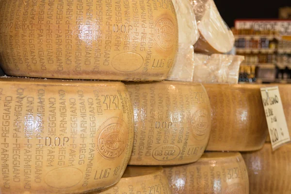 Round forms of Parmigiano Reggiano Italian cheese for sale — Stock Photo, Image