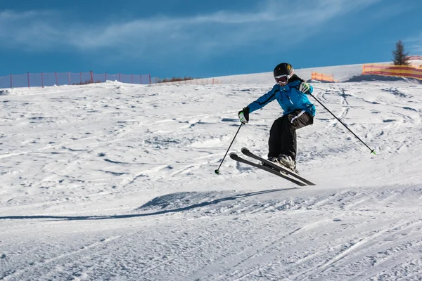 Pouco esquiador executa salto na neve — Fotografia de Stock