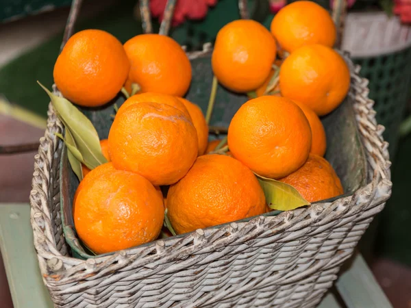 Frutas naranjas maduras en canasta de mimbre blanca — Foto de Stock