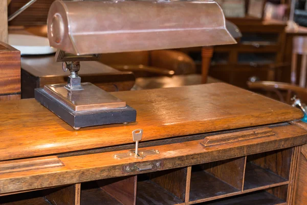 Escritorio de madera antigua con lámpara, cerradura de llave y compartimentos — Foto de Stock