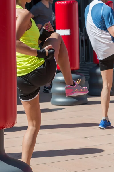 Ragazza pugilato e sacco da boxe in background — Foto Stock