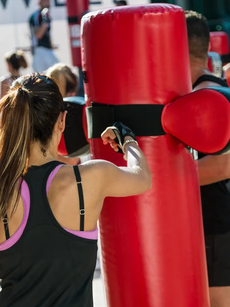 Genç kadın ve kum torbası: kadın Kickboxing egzersiz