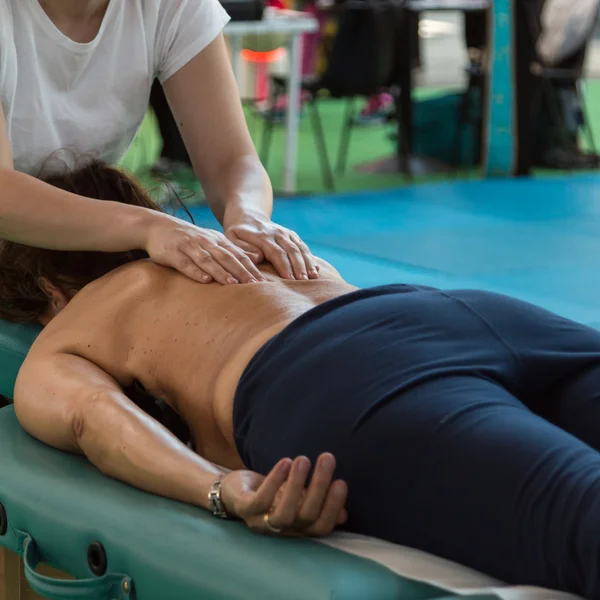 Женщина лежит на столе терапевта после занятий фитнесом — стоковое фото