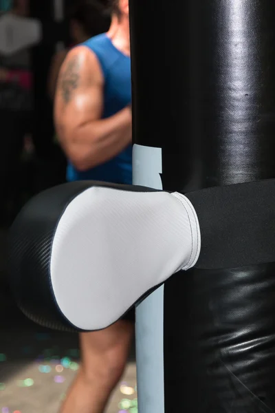 Zwarte bokshandschoen opvallend wit bokszak in Fitness klasse — Stockfoto