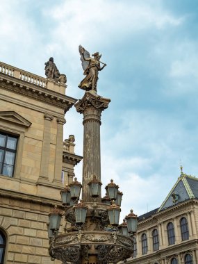 Bulutlu Gökyüzüne, Prag 'a, Çek Cumhuriyeti' ne Karşı Çok Lambalı Sokak Işığının Üzerinde Kanatlı Melek Heykeli.