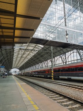 Çek Cumhuriyeti Prag 'daki ana istasyonun cam ve çelik kemer altında tren raylarının ve platformların yan görüntüsü.