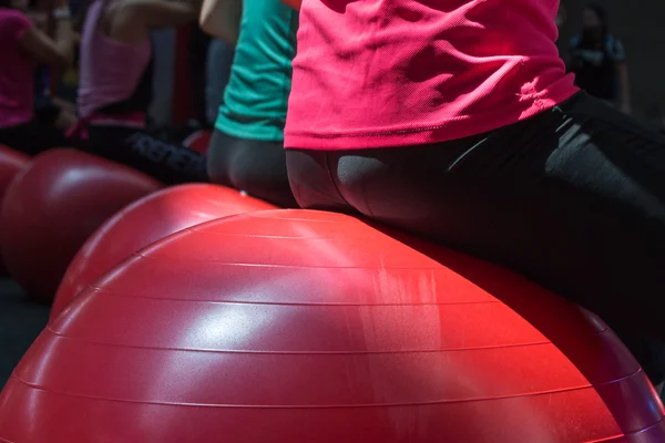 Nahaufnahme eines Mädchens, das auf einem großen roten Ball sitzt — Stockfoto