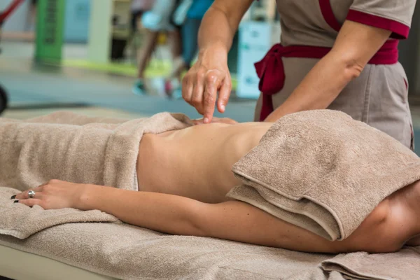 Hermosa joven recibiendo masaje en el abdomen en un spa — Foto de Stock