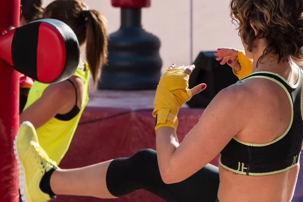 Chica joven haciendo Kickboxing con guantes en clase de fitness con Re —  Fotos de Stock
