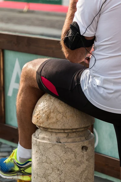 Niño con ropa deportiva y estuche de brazalete Smartphone esperando a R —  Fotos de Stock