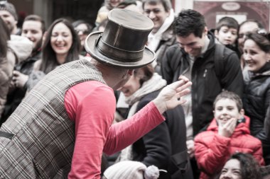 illusionist with magician's hat during street performance clipart
