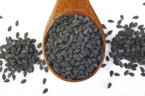 Black sesame seeds in wooden spoon — Stock Photo, Image