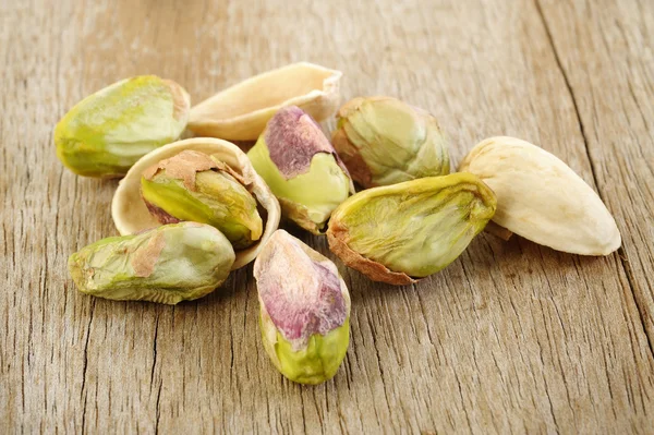 Noci di pistacchio su sfondo tavolo di legno — Foto Stock