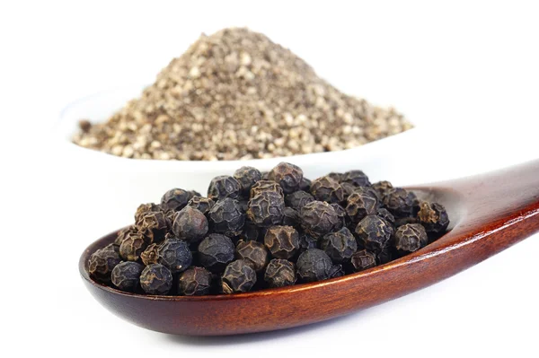 Black pepper in wooden spoon — Stock Photo, Image