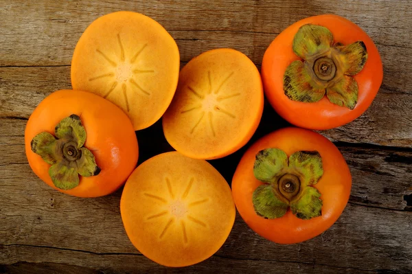 Fruta de caqui sobre fondo de madera — Foto de Stock