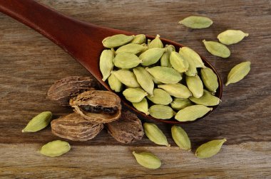 tahta kaşık içinde siyah ve yeşil kakule