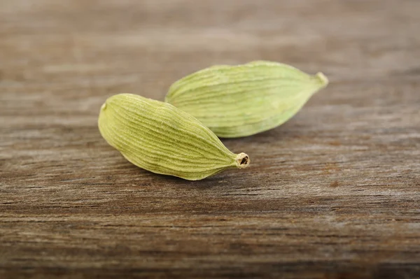 Filtros de cardamomo em fundo de madeira — Fotografia de Stock