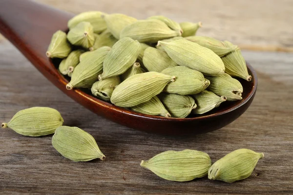 Baccelli di cardamomo verde in cucchiaio di legno — Foto Stock