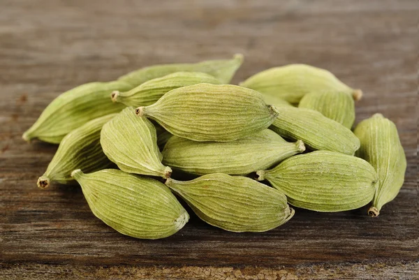 Vainas de cardamomo verde sobre fondo de madera —  Fotos de Stock