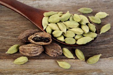 tahta kaşık içinde siyah ve yeşil kakule